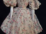une poupée qui porte une robe à fleurs