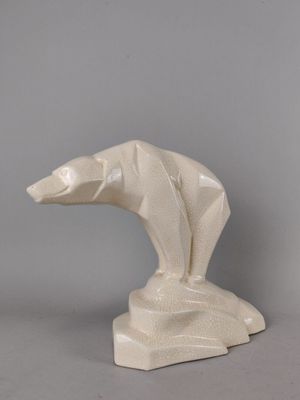 sculpture représentant un ours polaire posé sur un rocher, sur fond gris