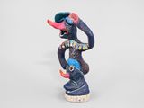 figurine of a monkey with a hat on his head on a white background