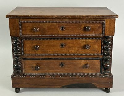 a small wooden chest of drawers on wheels on a white background