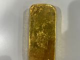 a close up of a piece of gold on a white surface