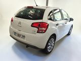 a white car that is parked in a white room