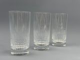 trois vases en verre transparent posés les uns à côté des autres sur une surface grise