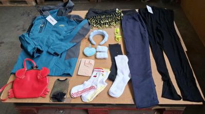 une table sur laquelle sont posés de nombreux vêtements et chaussures