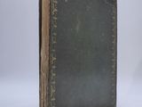 an old book sitting on top of a table next to a white wall