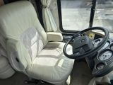 a bus driver ' s seat and steering wheel in the front of the bus