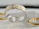 two wedding rings sitting on top of a clear display case