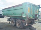 a green dump truck that is parked in a lot