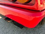 a close up of a red sports car with its tail lights on