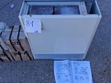 une caisse de glace posée par terre à côté d'une pile de cartons