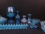 de nombreux objets en verre bleu posés sur une table