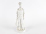 une figurine blanche représentant un homme portant un chapeau et une cravate