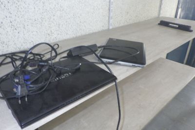 deux ordinateurs portables posés sur une table, reliés par des câbles