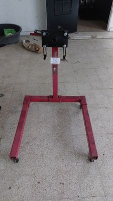 un support rouge sur lequel repose un objet noir, dans un garage