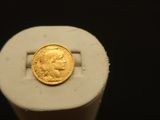 une pièce d'or posée sur une feuille de papier blanche