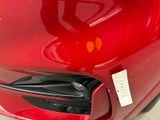 a close up of a red car with a sticker on it