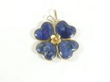 une image montrant un gros plan d'un pendentif en forme de fleur bleue sur fond blanc