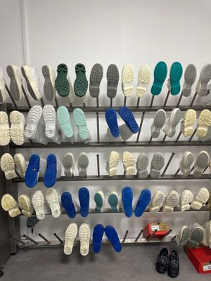 de nombreuses paires de chaussures suspendues à un porte-chaussures dans une pièce