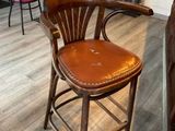 un tabouret de bar en bois avec une assise en cuir, dans une pièce