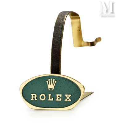 un gros plan sur un logo Rolex accroché à un crochet, sur fond blanc