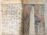 an open book with chinese writing on it sitting on a table
