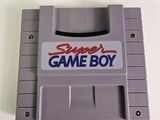 the gameboy is sitting on a white surface with a red and blue sticker on it