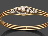 un gros plan d'un bracelet en or serti de diamants sur un fond noir