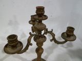 un candélabre en laiton avec trois bougies
