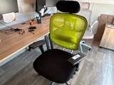 une chaise verte posée devant un bureau d'ordinateur