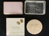 two soap bars and a soap dish sitting on a black surface
