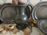 a lot of old metal dishes and pans on the counter