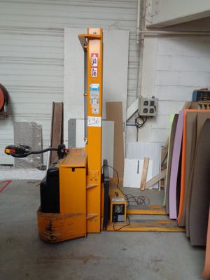 a fork lift in a garage with a lot of wood