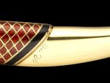 une pipe en or ornée d'un motif rouge et blanc
