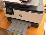a printer sitting on top of a wooden desk