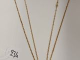 une boîte blanche sur laquelle sont posés un collier et une paire de boucles d'oreilles