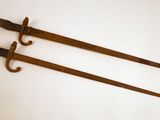 une paire de deux vieilles épées en bois posées sur une surface blanche