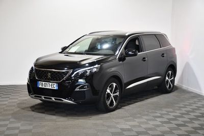 Le SUV noir est garé dans une pièce au sol carrelé en damier.
