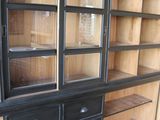 a black cabinet with drawers and a glass door