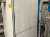a white refrigerator and a blue cart in a warehouse