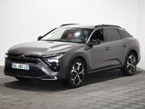 Le SUV gris est garé dans une pièce dont le sol est en damier.