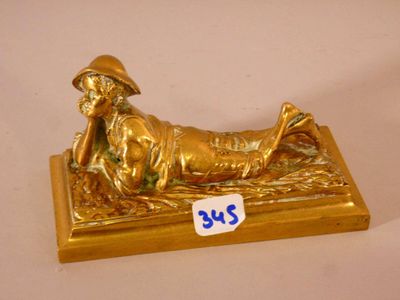une figurine en or représentant un homme allongé par terre