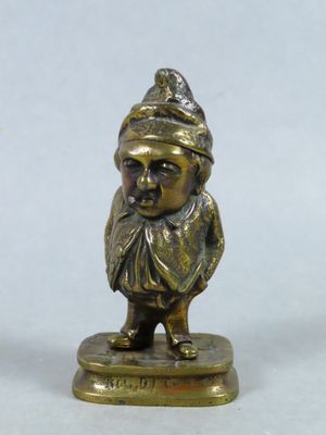 brass figurine of a man with a hat and scarf