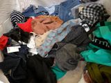 a pile of clothes on a bed with a tag on it