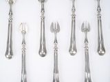 a lot of silver spoons and knives on a table