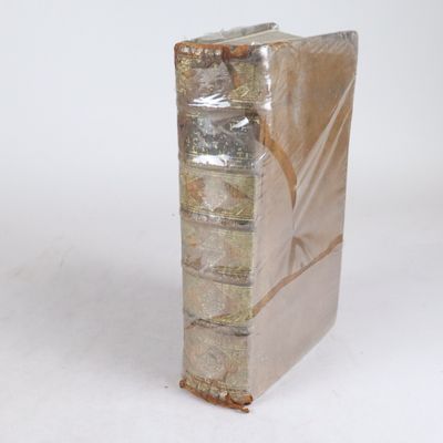 une pile de livres emballés dans du plastique posée sur une surface blanche
