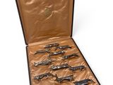 six silver spoons in a case on a white surface