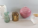 five different colored vases sitting on a white surface
