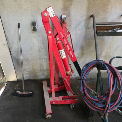 a picture of a red hydraulic jack in a garage
