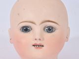a doll head with big eyes on a white surface