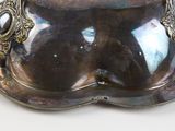 a silver plate with a bowl on it on a table
